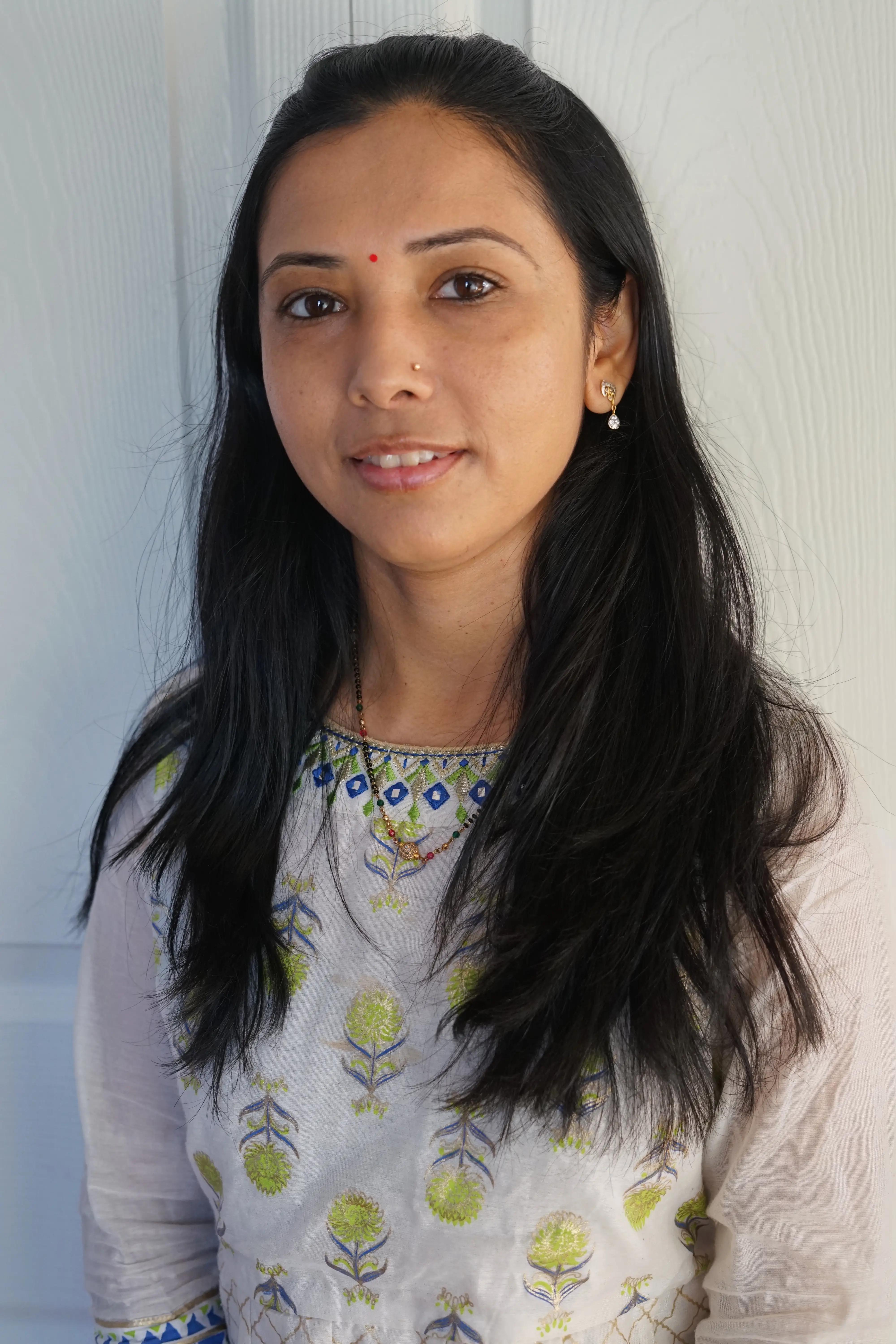 Janki, smiling, in soft natural light